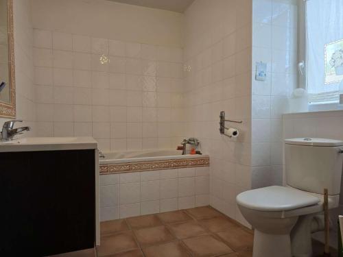 a bathroom with a toilet and a tub and a sink at 751 - Maison de caractère avec magnifique jardin clos in Erquy