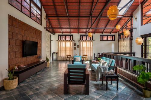 a lobby with chairs and a flat screen tv at The Kumberi Manor in Ammatti