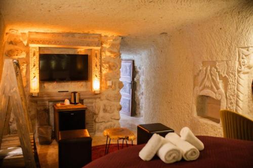 a bedroom with a bed and a television in a room at Rose Moon Cave in Macun Çiftliği