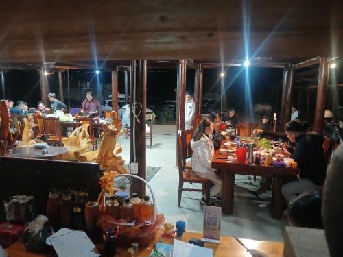 a group of people sitting at tables in a restaurant at Tày Homestay Pác Bó - Cao Bằng in Cao Bằng