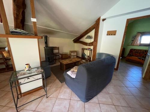 a living room with a blue couch and a table at Gîte des Monts in Saint-Izaire