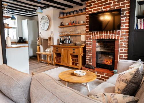 a living room with a couch and a fireplace at Old Customs House in Harwich