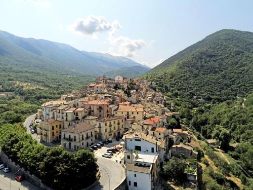 a town on a hill with a road and mountains at Casa Cicone in Pettorano sul Gizio