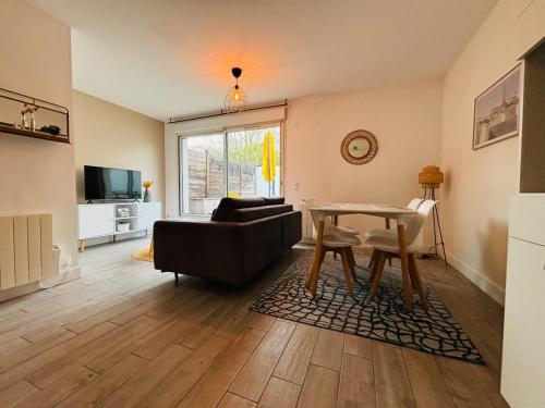 una sala de estar con un sofá y una mesa en Appartement terrasse entre Paris et Disney, en Bry-sur-Marne