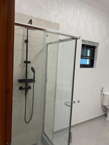 a shower in a bathroom with a glass shower stall at Villa Djonasse, a Residence of Exellency in Fombeni