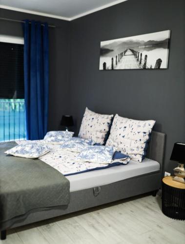 a bedroom with a bed with blue curtains at Apartament Oslo in Pniewy