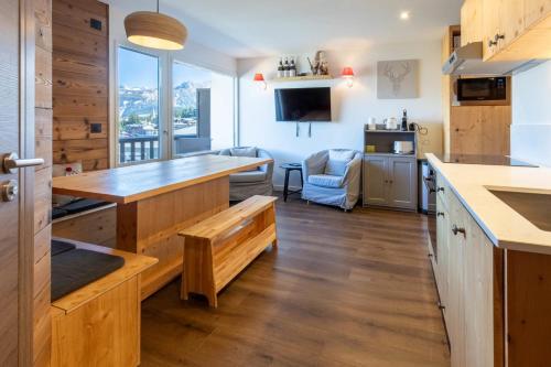 a kitchen with wooden counters and a large window at La Foret du Praz 501 in Courchevel
