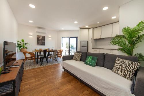 a living room with a couch and a dining room at Praia da Rocha Beach Retreat in Portimão