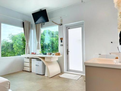 a white room with a desk and a large window at Kenting South Border DeSign Hotel in Eluan