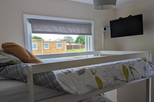 een bed in een kamer met een raam bij 2 Bed Chalet - Sleeps 5 - Free Parking - Tv in Great Yarmouth