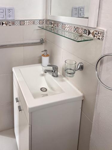 a white bathroom with a sink and a mirror at Refugio Del Corazón in Capilla del Monte