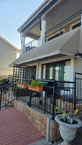 a building with tables and chairs in front of a building at Accommodation Unwind in Langebaan