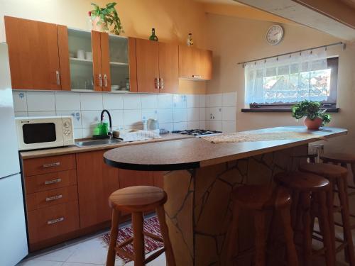 een keuken met een aanrecht met krukken en een magnetron bij Sárka in Štrba