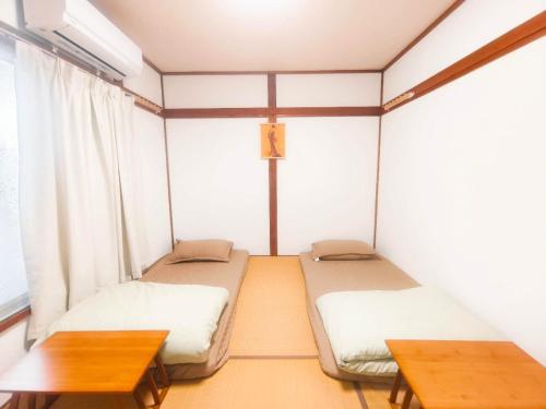 a room with two twin beds and a table at 奈良清舎 事故防止の観点から18歳-55歳の方限定 仅限18-55岁客人入住 For guests aged18-55only in Nara