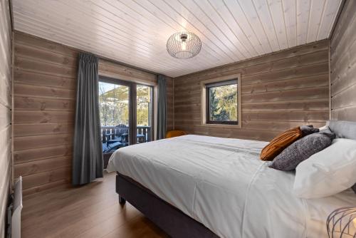 - une chambre avec un grand lit et des murs en bois dans l'établissement Sigr Hytte - 8p - With Sauna, à Vradal