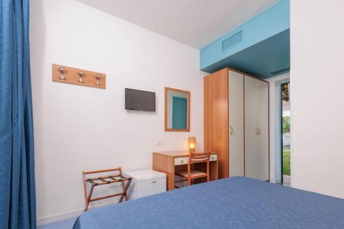 a bedroom with a bed and a desk with a chair at Villa Paeonia in Paestum