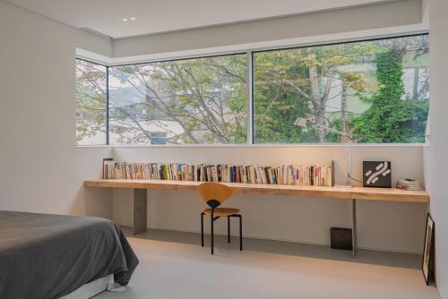 ein Schlafzimmer mit Fenster und einem Schreibtisch mit Büchern in der Unterkunft prenom in Paju