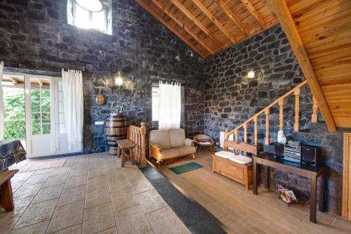 a living room with a stone wall at Adega Poça in Prainha de Baixo