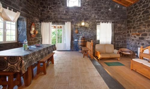 a living room with a stone wall at Adega Poça in Prainha de Baixo