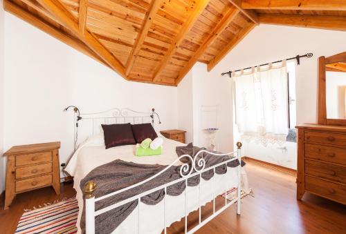 Prainha de BaixoにあるAdega Poçaの白いベッドと木製の天井が備わるベッドルーム1室が備わります。