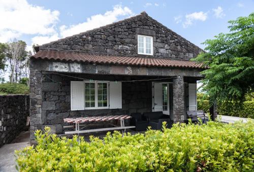 an old stone house with a patio in front at Adega Poça in Prainha de Baixo