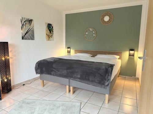 a bedroom with a bed and a clock on the wall at Maison Kaiser - Studio apartment in Wadern