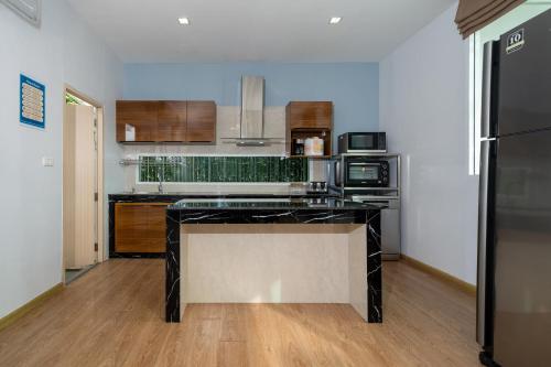 a kitchen with a black counter top in a room at Phuket La Siesta Pool Villas & Pool Access Rooms in Nai Harn Beach