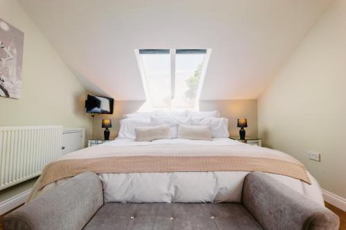 a bedroom with a large bed with a window at Swallows Lodge in Droitwich