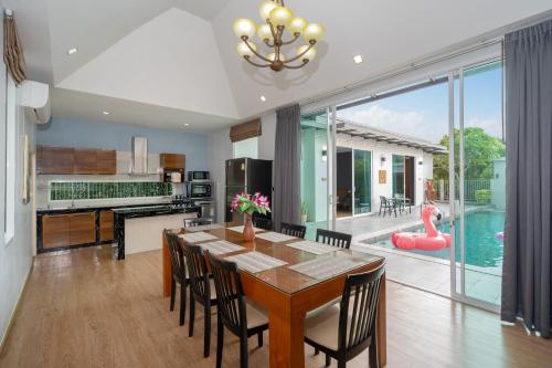 una cucina e una sala da pranzo con un tavolo e una piscina di Phuket La Siesta a Nai Harn Beach