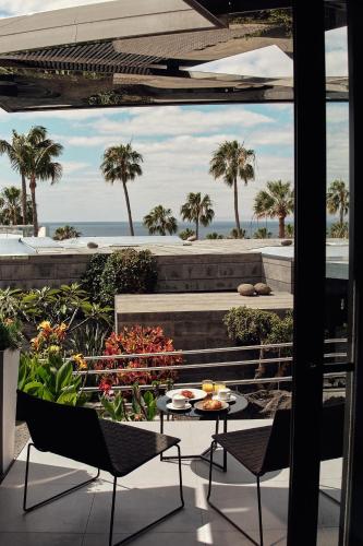 a patio with a table and chairs and a view of the ocean at La Isla y el Mar, Hotel Boutique in Puerto del Carmen