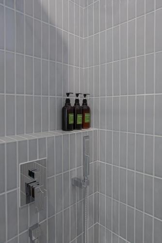 Zwei Flaschen Öl stehen auf einem Regal im Badezimmer. in der Unterkunft prenom in Paju