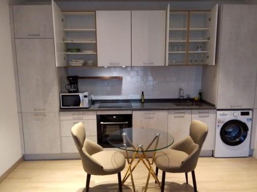 a kitchen with a glass table and chairs at Big 1 Bedroom Apartment at Cantonments - Pool, Gym, Game Room in Accra