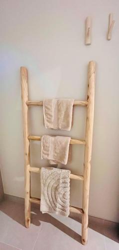 a towel rack with three towels on a wall at Lodge Rose's Heart in Bramberg am Wildkogel