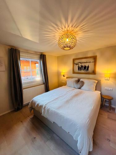a bedroom with a large bed and a chandelier at Lodge Rose's Heart in Bramberg am Wildkogel