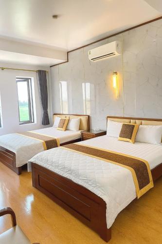 a hotel room with two beds in a room at HQ Hotel & Apartment in Hai Phong