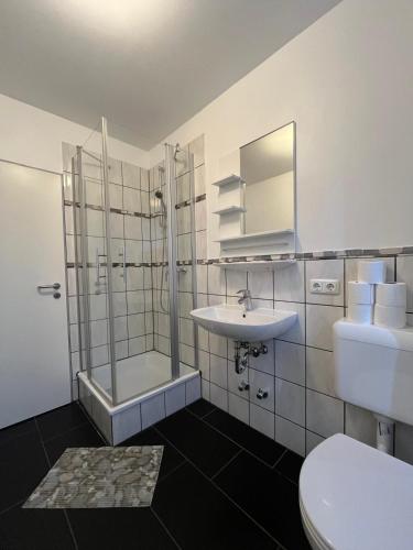 a bathroom with a shower and a sink and a toilet at Villa Jesteburg in Jesteburg