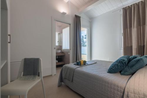 a bedroom with a bed with blue pillows and a chair at Villa Silvia in Montemaggiore al Metauro
