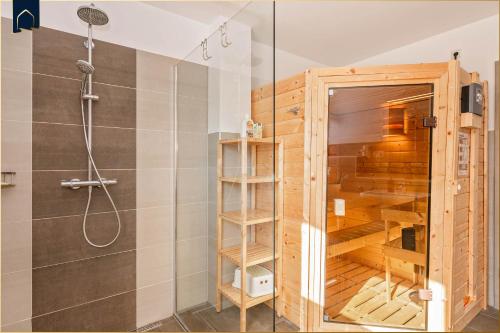 a shower with a glass door in a bathroom at Ferienanlage Sonneninsel Haus Himmelblau Erdgeschoss in Loddin