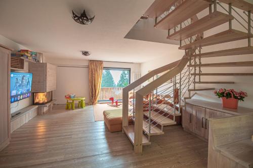 a room with a staircase and a living room with a television at CAMPIGLIO Panorama sul Brenta in Madonna di Campiglio