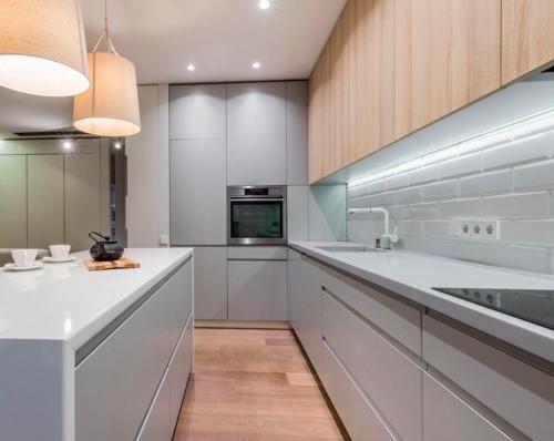 a kitchen with white cabinets and a counter top at Stilingas dviejų kambarių butas in Vilnius