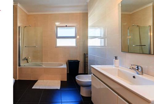 a bathroom with a tub and a toilet and a sink at G at Bela Baia Salir in Salir de Porto