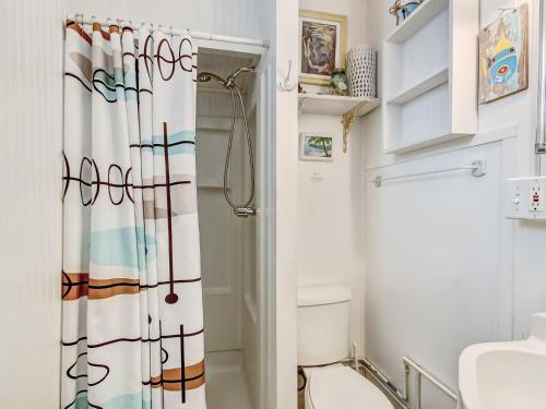 une salle de bain avec un rideau de douche et des toilettes dans l'établissement Surf Puppy, à Tybee Island