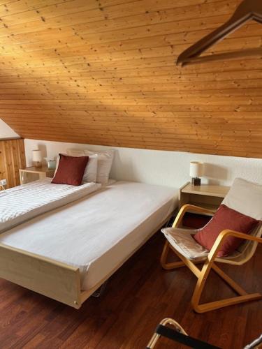 a bedroom with two beds and a chair in it at Auberge du Prévoux in Le Locle