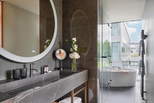 a bathroom with a sink and a mirror at Hyatt Regency Zurich Airport Circle in Kloten
