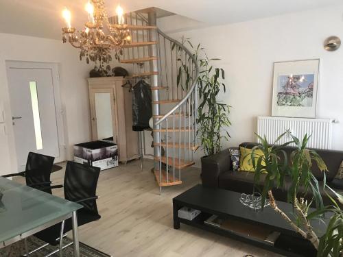 a living room with a couch and a staircase at Bezauberndes Gästehaus im Grünen mit Terrasse in Bad Wildbad