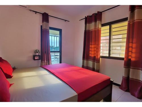 a bedroom with a bed and a window with curtains at La MAISON BLANCHE - A - CENTRAL - CALME - WIFI - White Butterfly Hostel in Dakar
