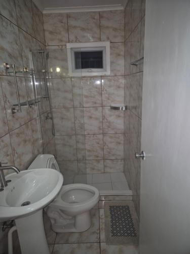 ein Badezimmer mit Waschbecken, Toilette und Dusche in der Unterkunft Tahir & Tamir Apartment in Willemstad