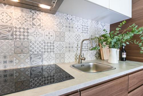 a kitchen with a sink and a tile wall at Casa Do Raio City Center Ap By Sé Apartamentos in Braga
