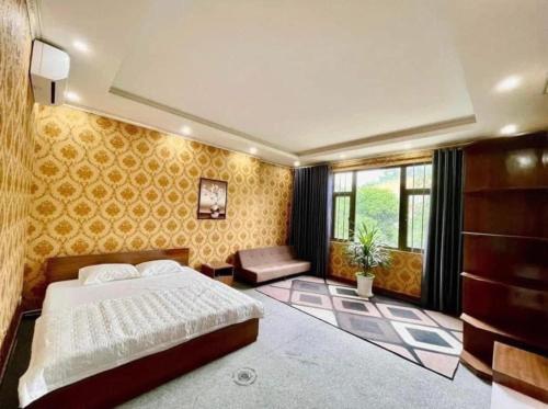 a bedroom with a large bed and yellow wallpaper at Cô Chung Hotel in Lao Cai