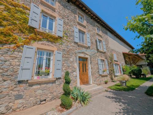 a stone house with blue shutters on it at La Maison d'Arlette - Maison d'Hôte et Gite au coeur de l'Isère à 10 mn de Voiron, capitale de la Chartreuse, et du Lac de Paladru in Saint-Blaise-du-Buis